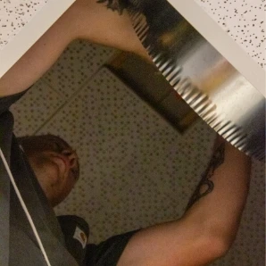HVAC technician reaching into ceiling ductwork during an installation or repair.