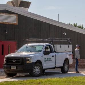 A Big Horn Heating & Cooling truck parked outside a large building.